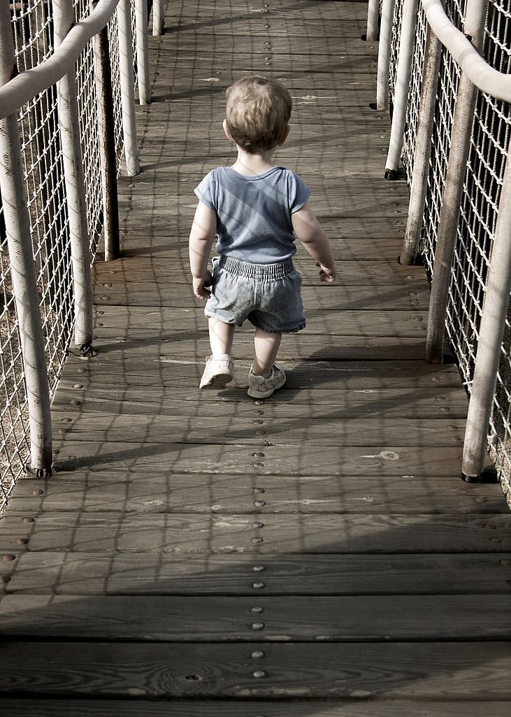 Baby walking on bridge